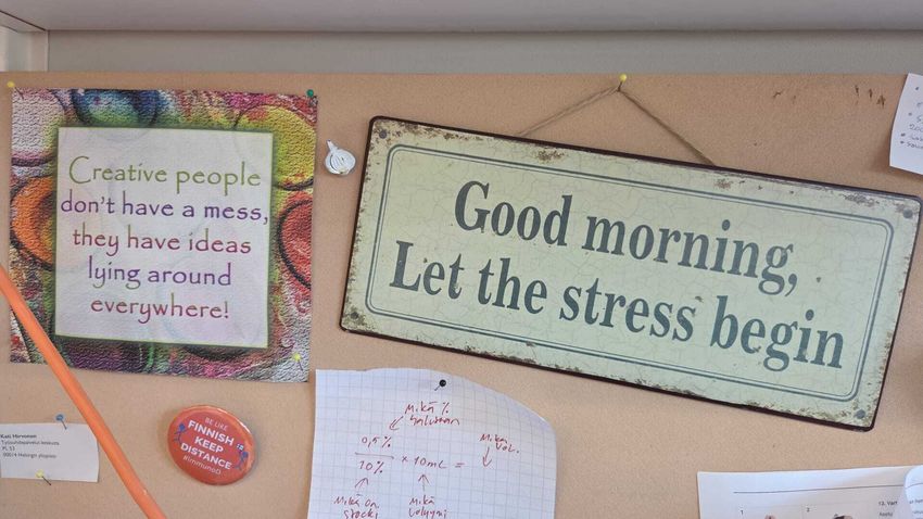 Image of various décor pinned on a corkboard. The signs say, “Creative people don’t leave a mess, they have ideas lying around everywhere!” and “Good morning, let the stress begin.” Image of various décor pinned on a corkboard. The signs say, “Creative people don’t leave a mess, they have ideas lying around everywhere!” and “Good morning, let the stress begin.”