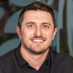 Andrew Bubak wears a dark shirt in a headshot.