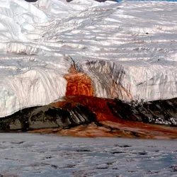 A blood red waterfall, Blood Falls, is shown as it exits Taylor Glacier and flows into Lake Bonney in Antarctica.