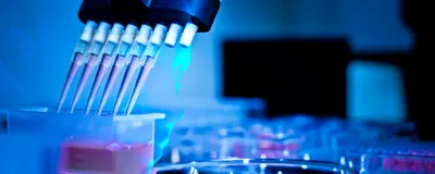 A robotic face, representing an AI scientist, is overlayed under an image of a multi-pipet taking up red liquid in a molecular biology wet lab that is bathed in blue light.