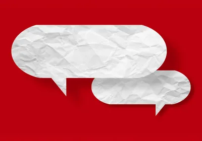 White speech bubble crumpled paper isolated on red background, indicating the debates surrounding the use of AI in Nikon Small World Photography competition.