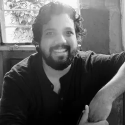 Bharath Thampi smiles in a black and white headshot photo.