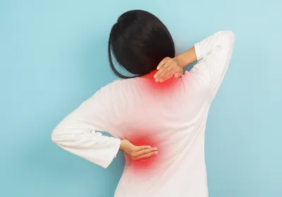 View of the back of a woman with neck and back pain.