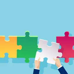 A photo of a yellow, green and pink puzzle piece assembled in a line with a gap between the green and pink piece on a blue background. A pair of hands lefts a white puzzle piece to fill the gap in the puzzle. 
